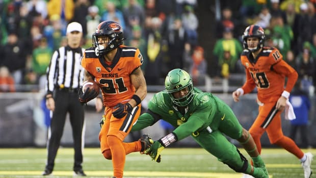 Nov 27, 2021; Eugene, Oregon, USA; Oregon State Beavers running back Trey Lowe (21) breaks away from Oregon Ducks defensive tackle Brandon Dorlus (3) during the second half at Autzen Stadium. The Ducks won 38-29. Mandatory Credit: Troy Wayrynen-USA TODAY Sports